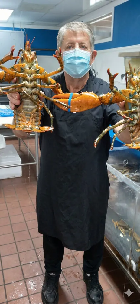 Chef Dave Krider holding fresh lobsters in his kitchen